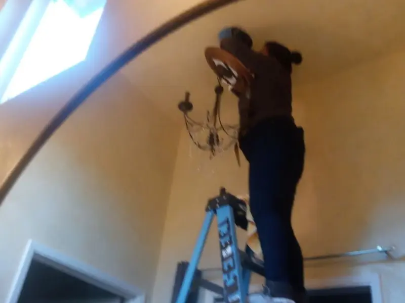 Electrician installing a chandelier in a Halifax residence